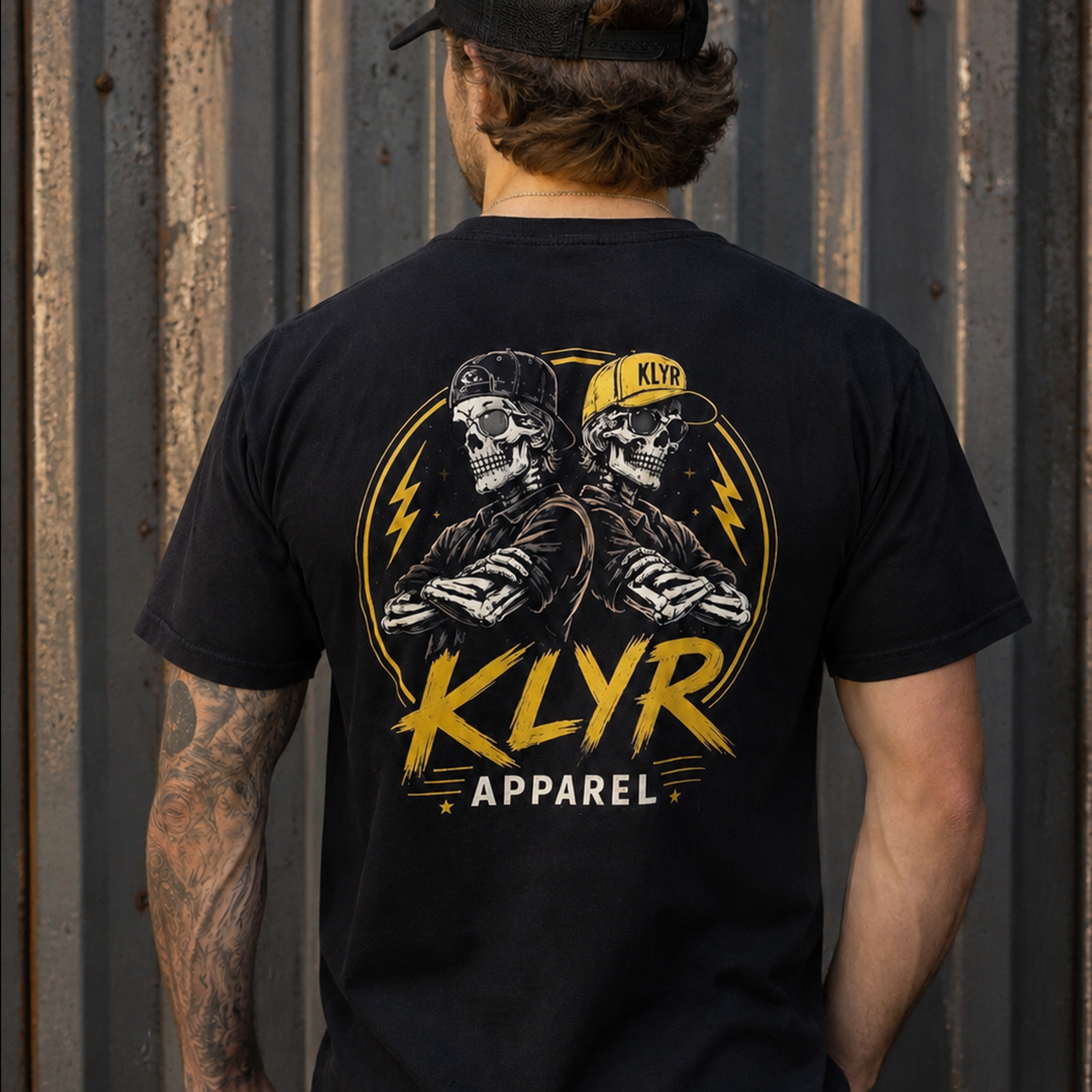 Lifestyle back view of a model wearing the black KLYR Homies Tee with its large dual-skull graphic.
