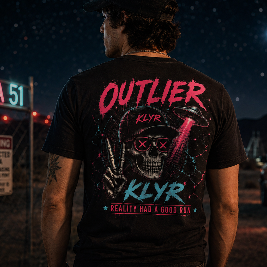 Rear lifestyle view of the black KLYR Reality Had a Good Run Tee showcasing the colorful neon skull and UFO back graphic outdoors at night.