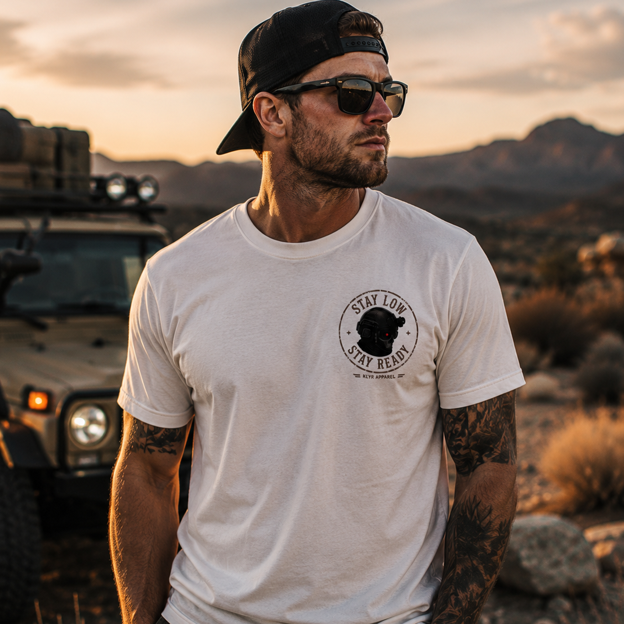 Front lifestyle view of the white KLYR Stay Low Stay Ready Tee featuring the Stay Low Stay Ready tactical helmet chest logo.