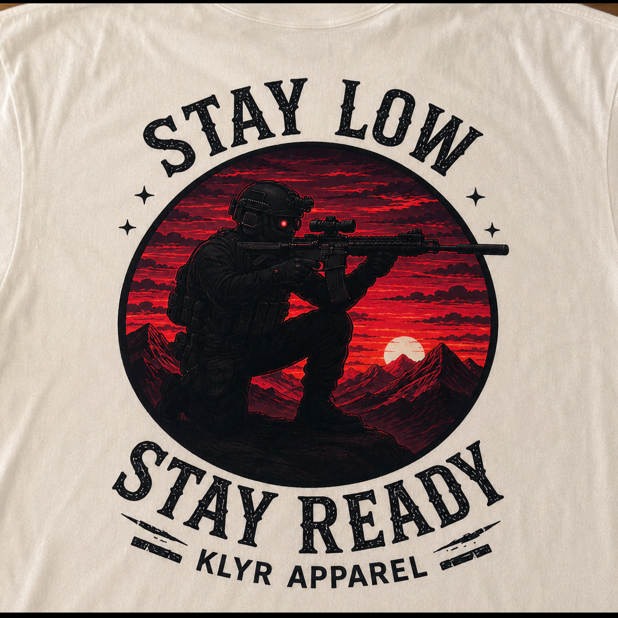 Close-up of the Stay Low Stay Ready back graphic featuring a tactical operator with a rifle against a red sunset mountain landscape.