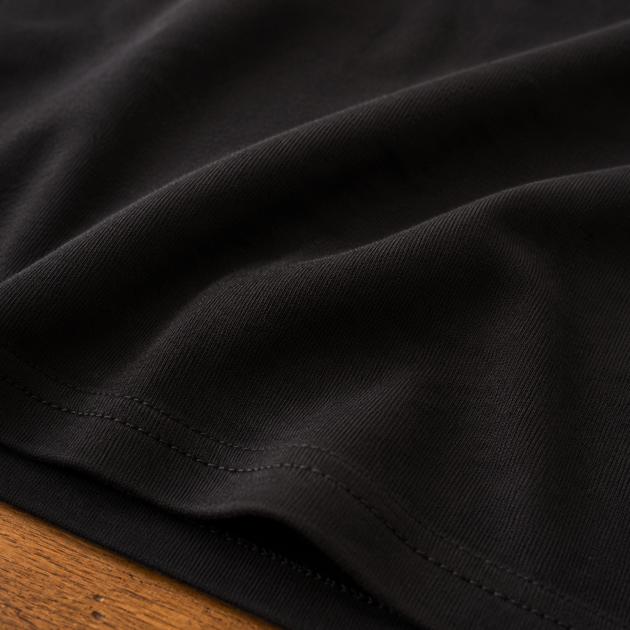 Close-up of the premium Next Level 6210 CVC fabric on the black KLYR Pull Up Pop Out Tee highlighting its soft texture and quality stitching.