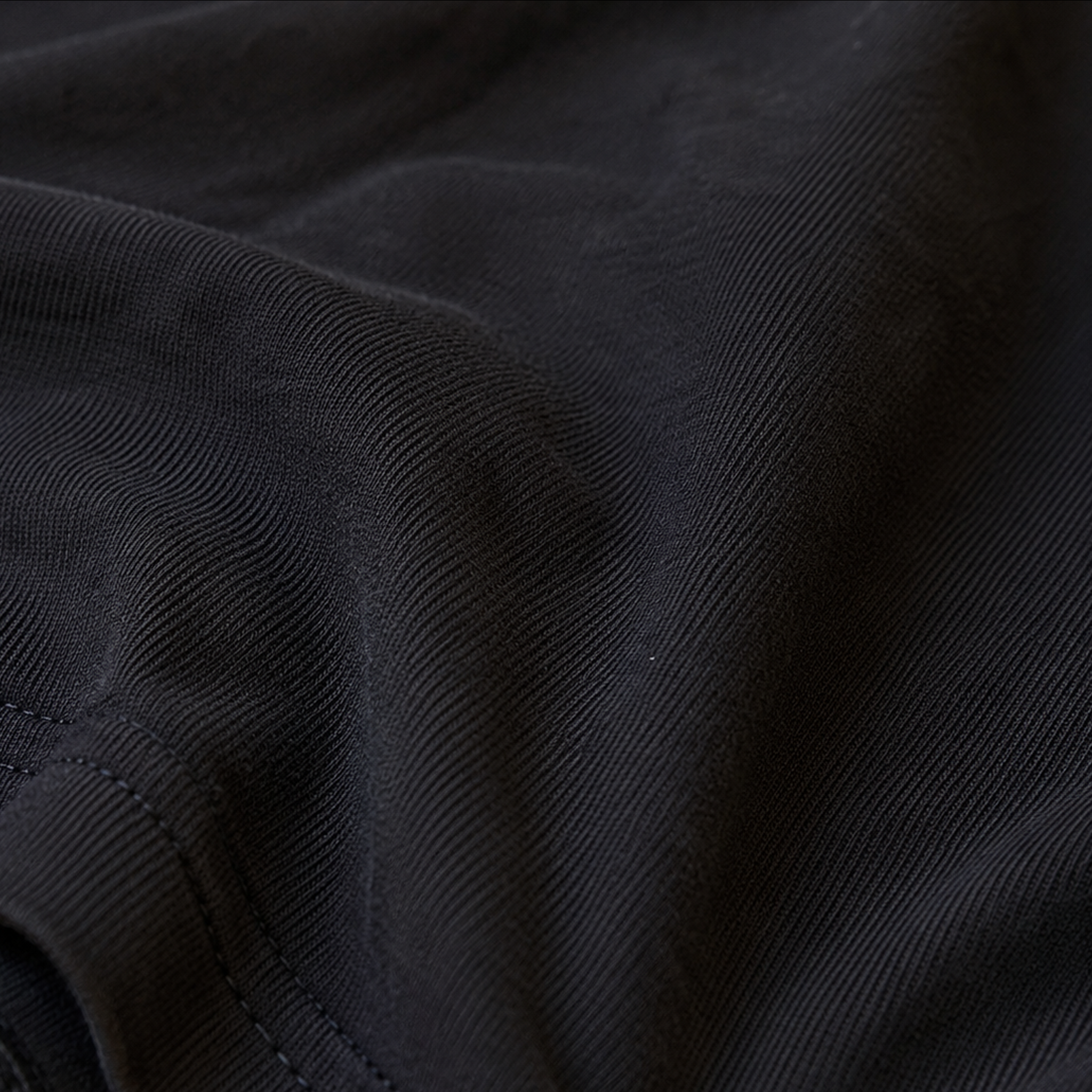 Close-up of the premium Next Level 6210 CVC fabric on the black KLYR Good Times Bad Decisions Tee highlighting its soft texture and quality stitching.