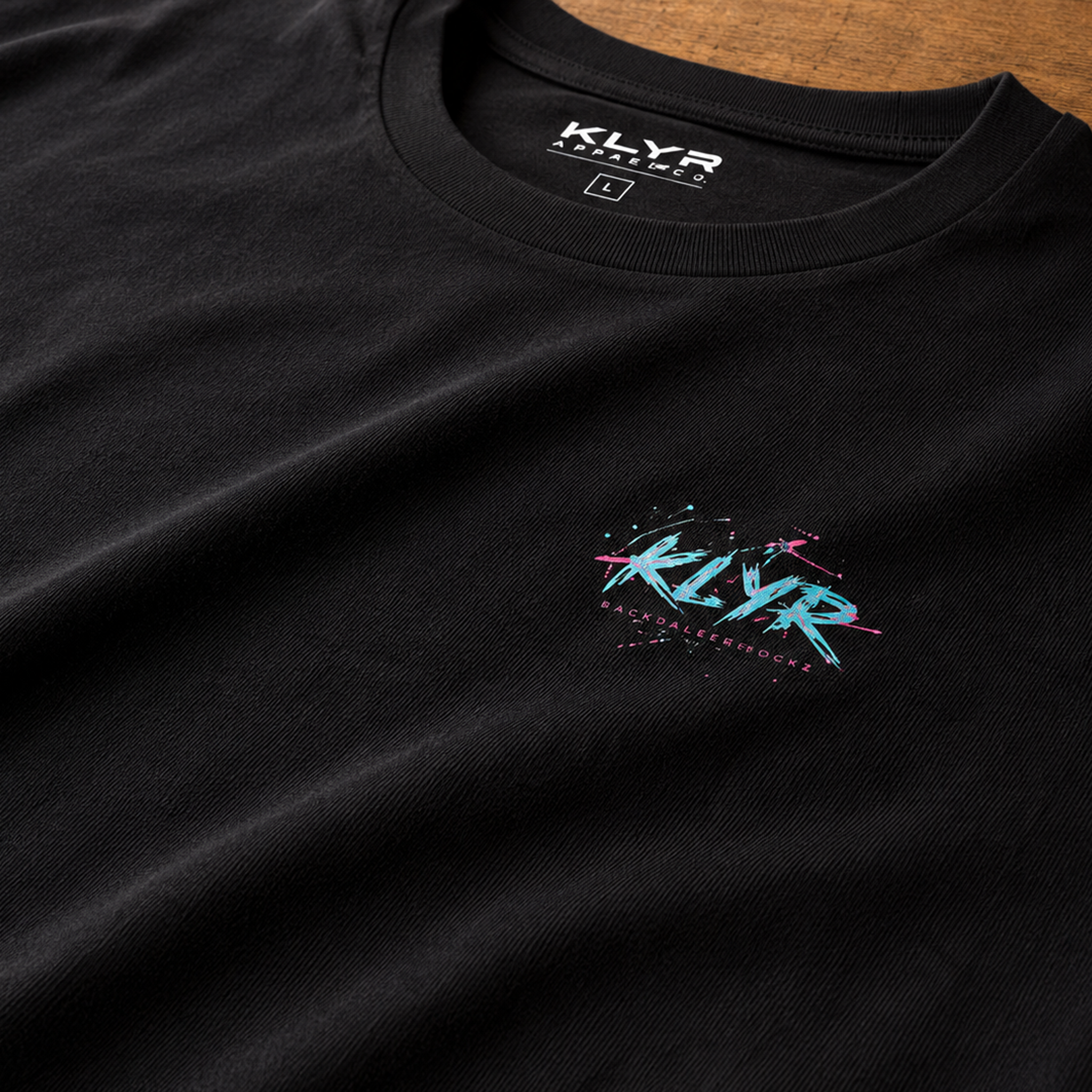 Close-up of the premium Next Level 6210 CVC fabric on the black KLYR Reality Had a Good Run Tee highlighting its soft texture and chest logo.