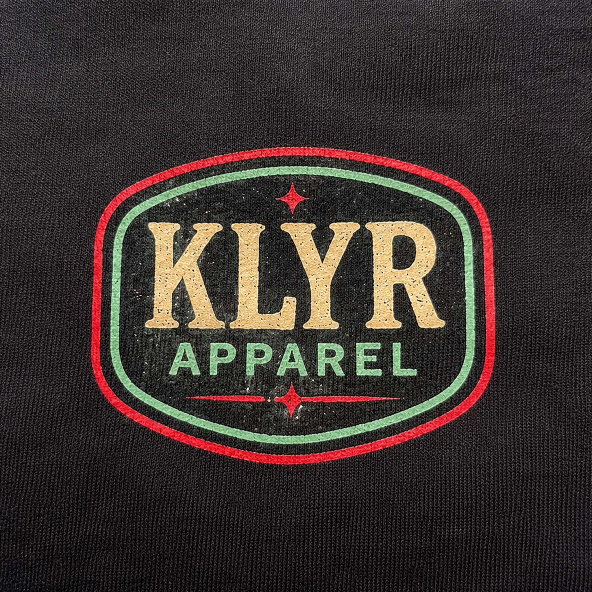 Detailed close-up of the vintage KLYR Apparel chest logo printed on the black After Hours Tee.