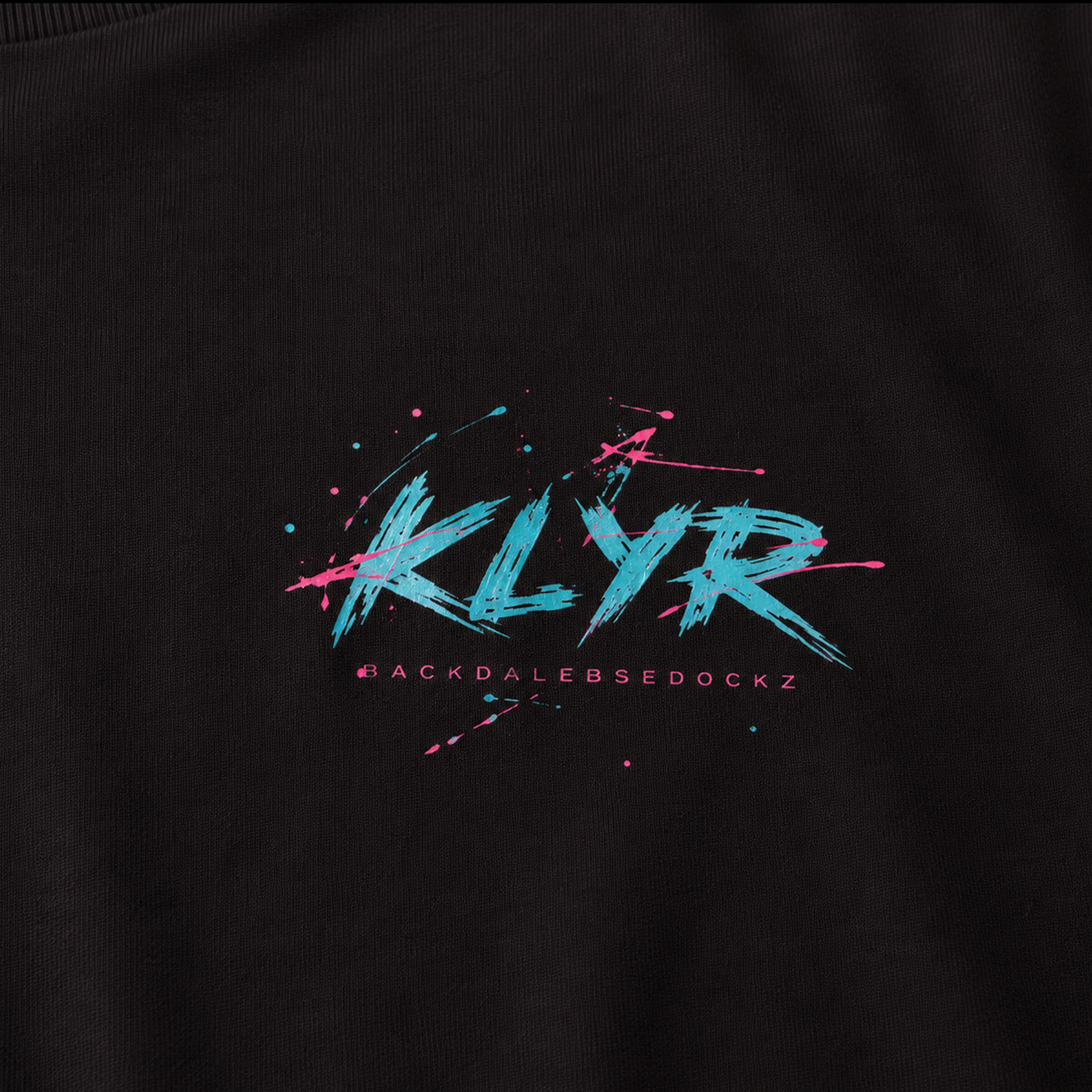 Detailed close-up of the Reality Had a Good Run Tee chest logo featuring the colorful retro KLYR graphic on a black premium t-shirt.
