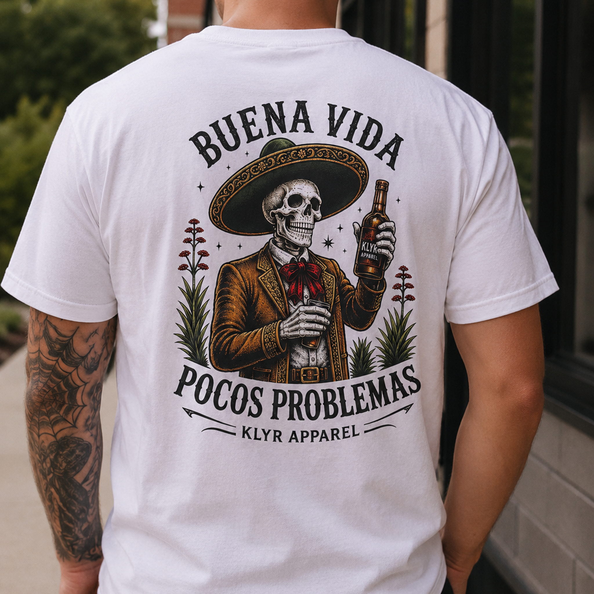 Person wearing the white Buena Vida Social Club Tee with the Pocos Problemas back graphic visible.
