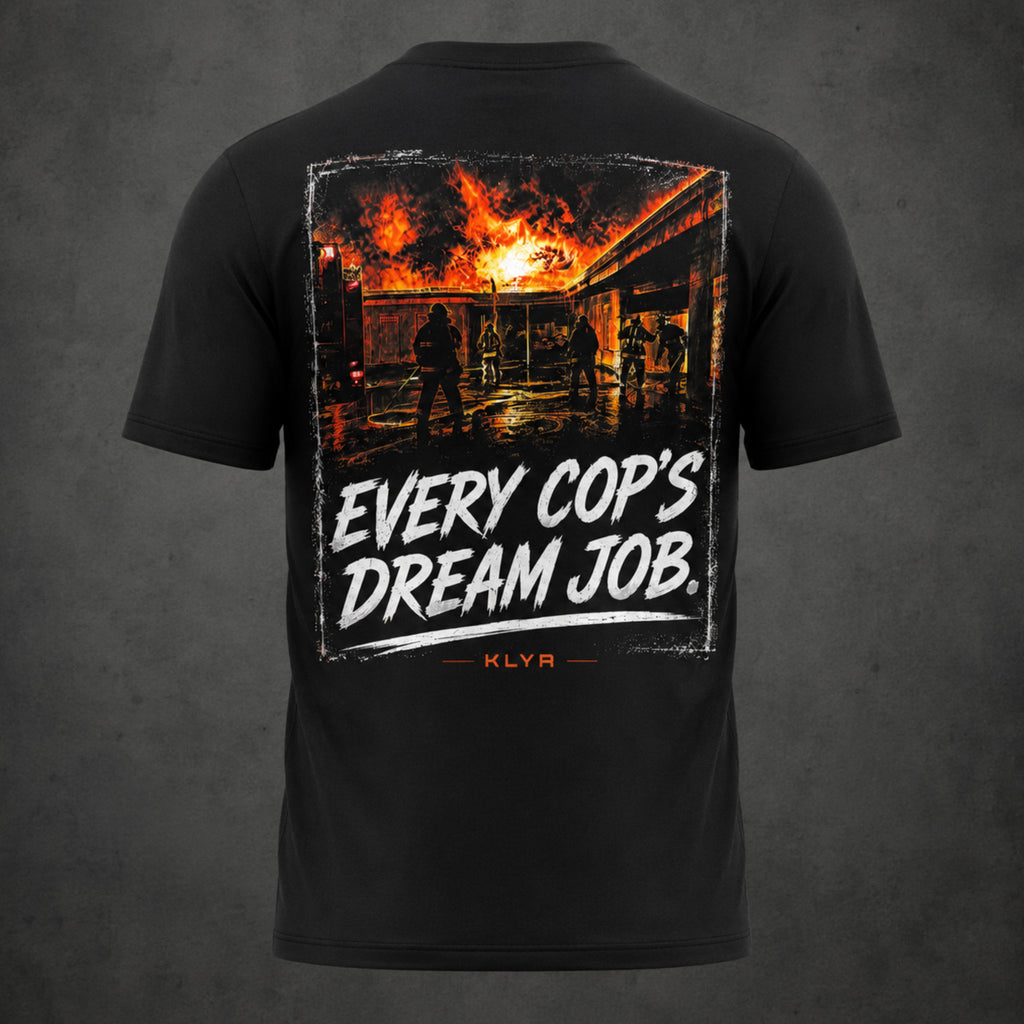 Back view of the black KLYR Every Cop’s Dream Job Tee featuring firefighters beneath a burning structure.