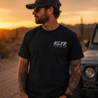 Front view of the black Every Cop's Dream Job Tee featuring a white KLYR chest logo. 