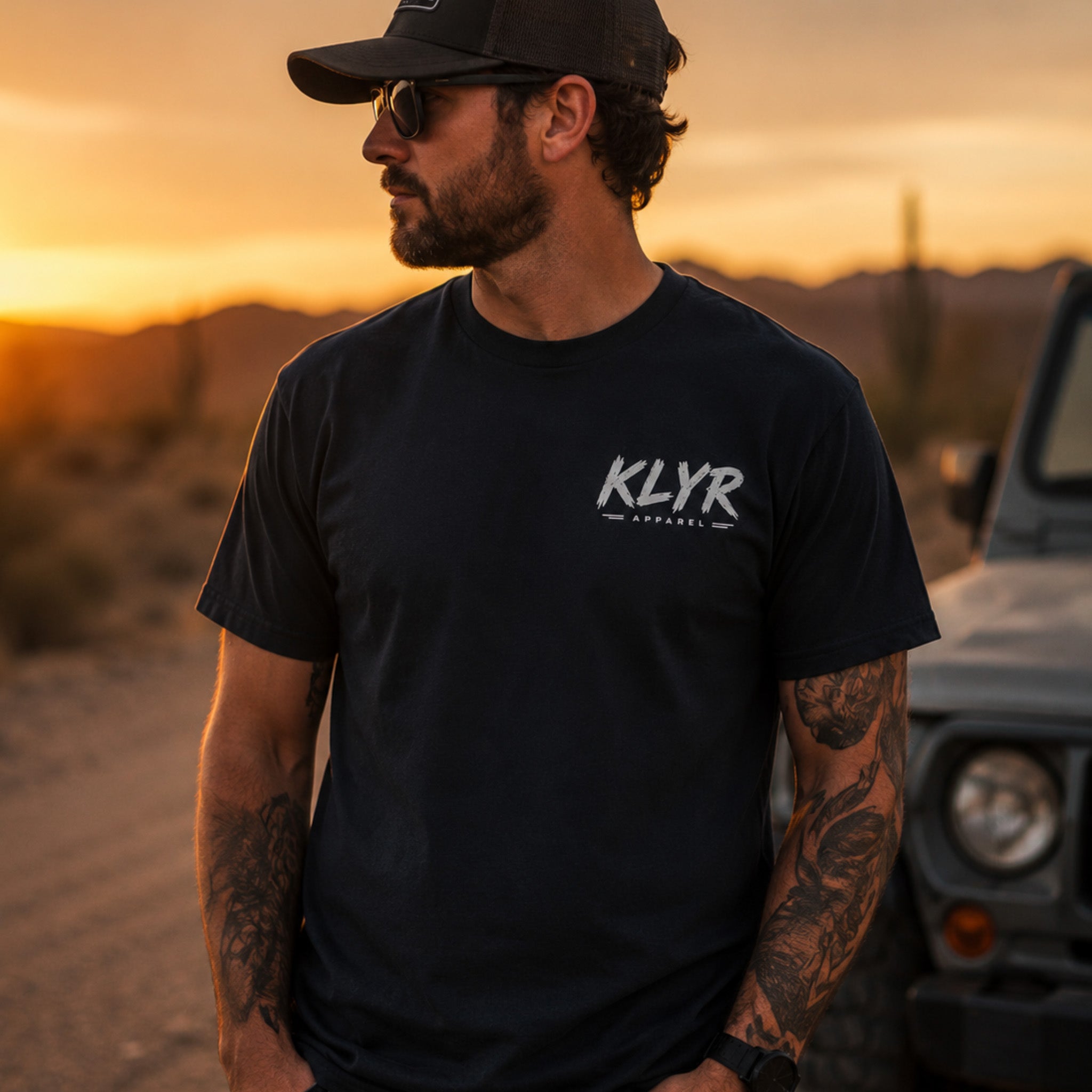 Person wearing the black Every Cop’s Dream Job Tee with the white KLYR chest logo visible.