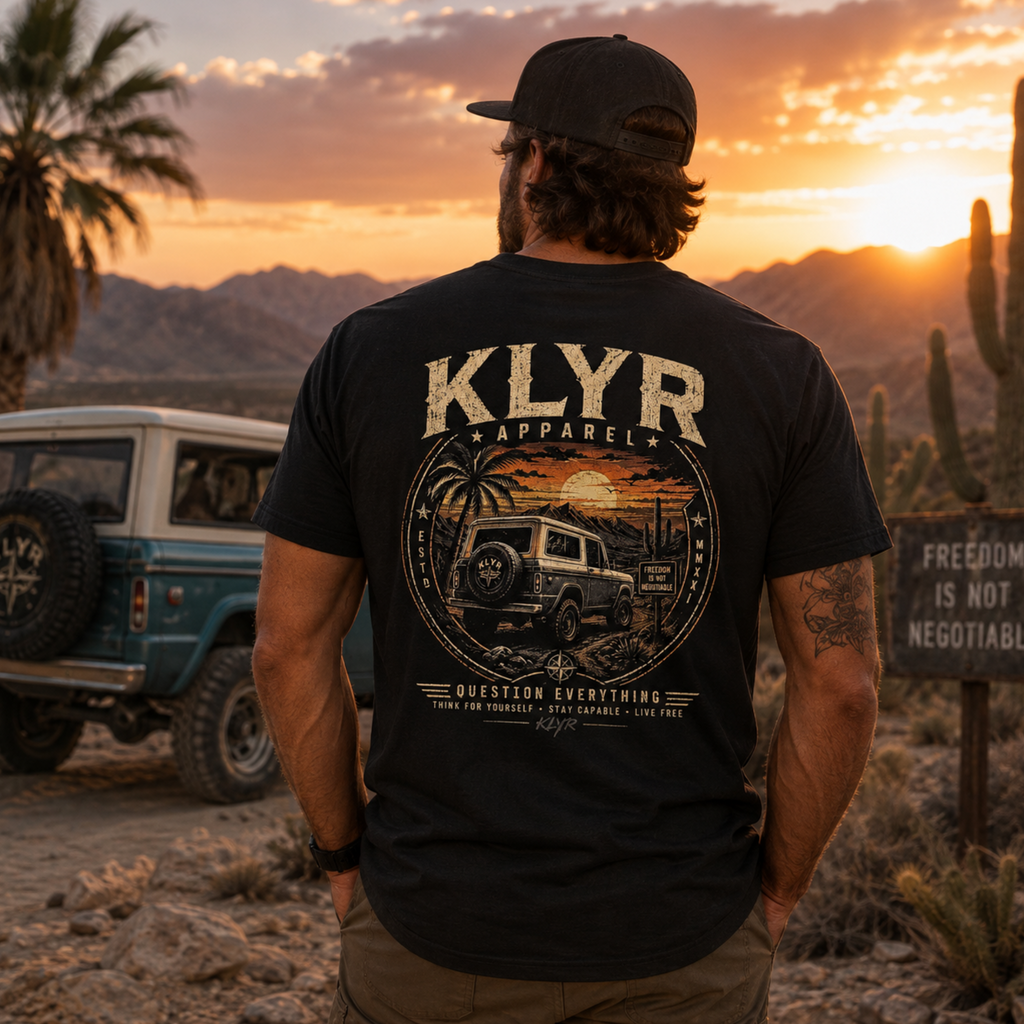 Person wearing the black Freedom Is Not Negotiable Tee near an off-road vehicle with the desert back graphic visible.