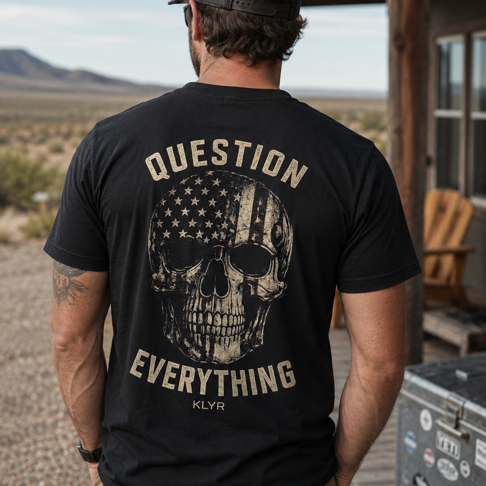 Person wearing the black KLYR Independent Tee with the Question Everything back graphic visible.