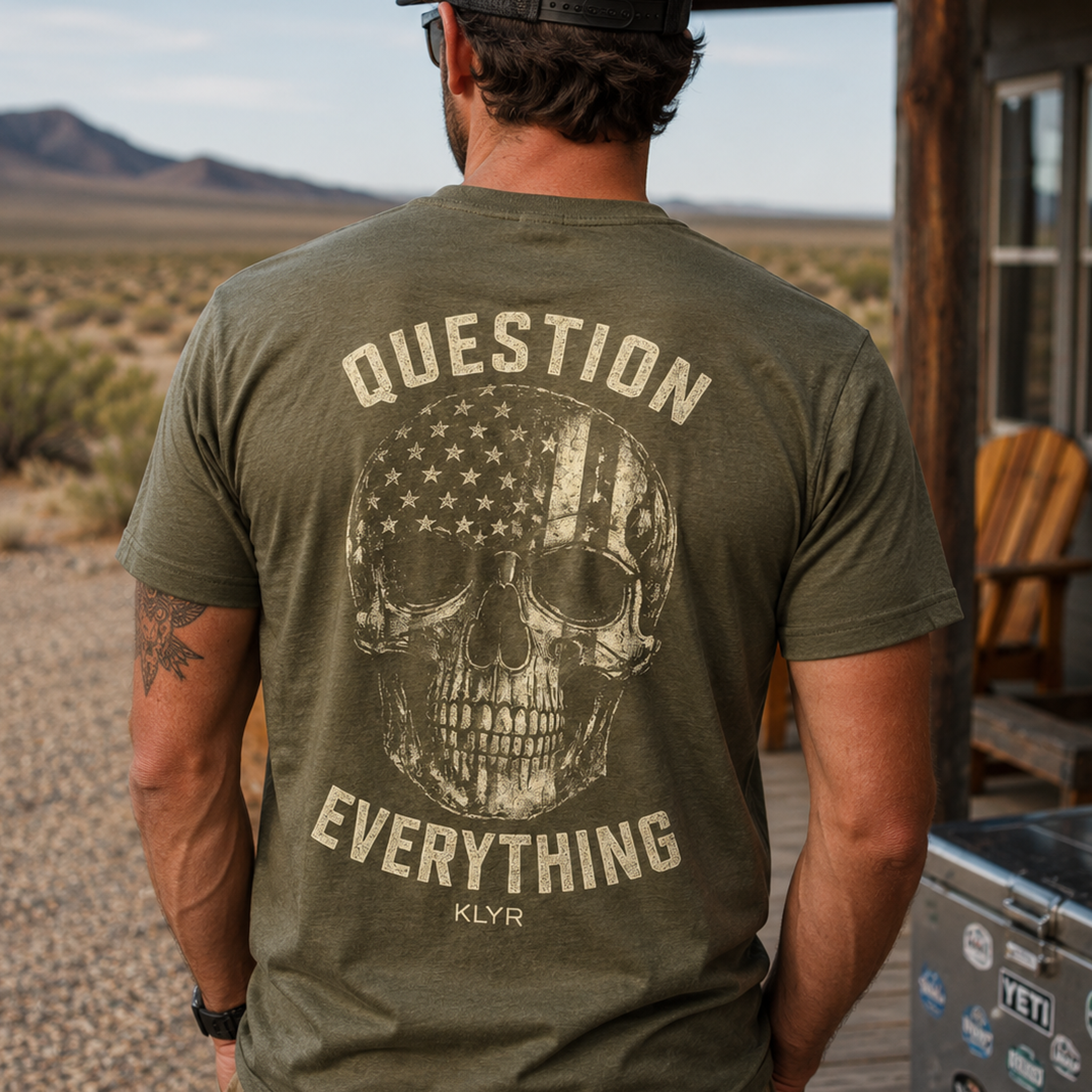 Person wearing the military green Independent Tee with the distressed skull back graphic visible.