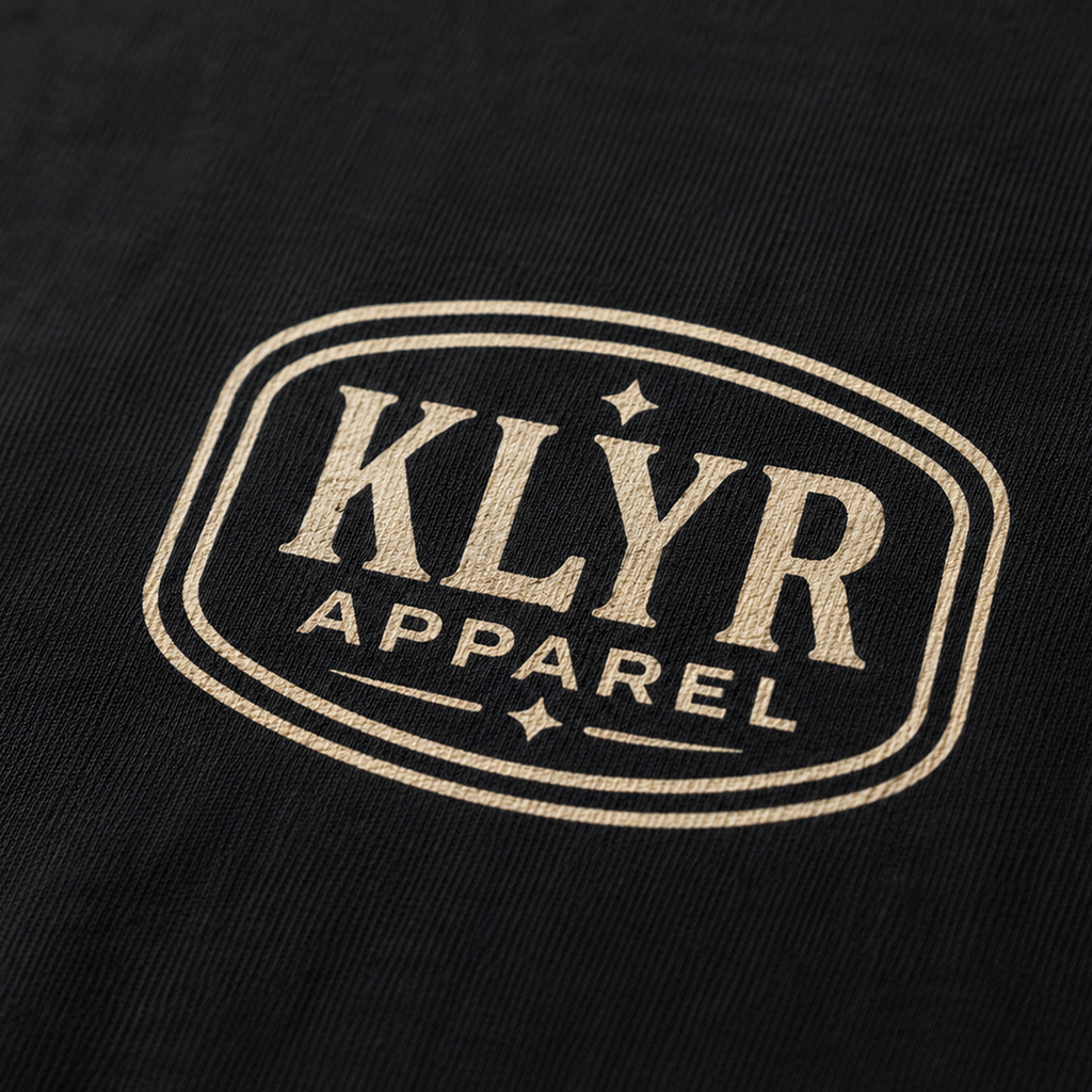 Close-up of the cream KLYR Apparel chest badge on the Last Warning Tee.