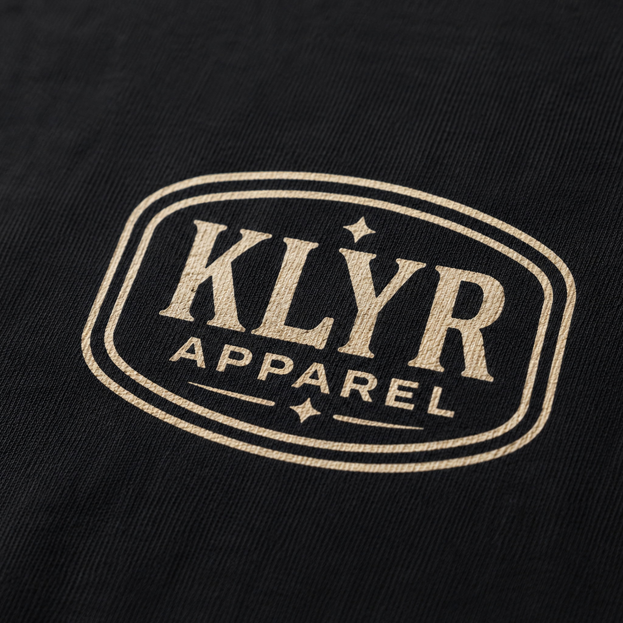Close-up of the cream KLYR Apparel chest badge on the Last Warning Tee.