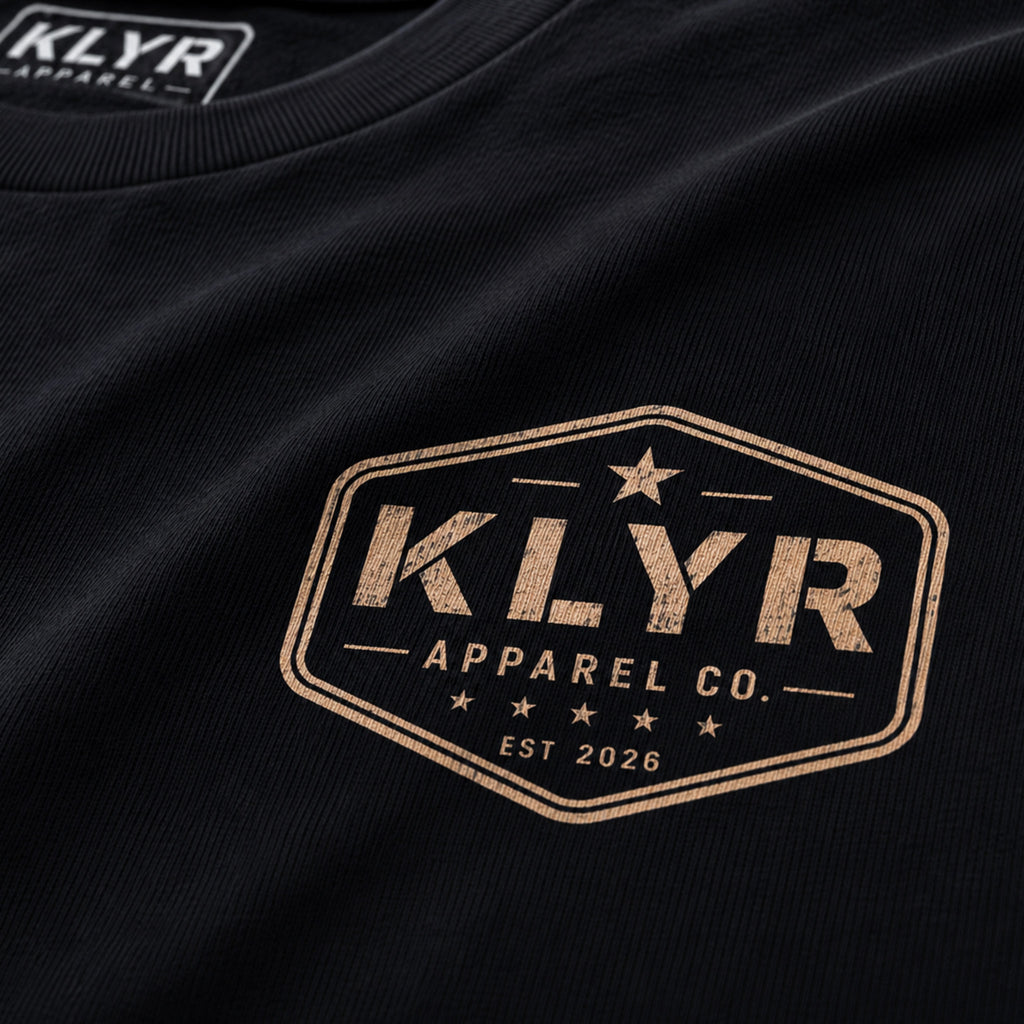 Close-up of the distressed cream KLYR Apparel chest badge on the Work Hard Stay Humble Tee.